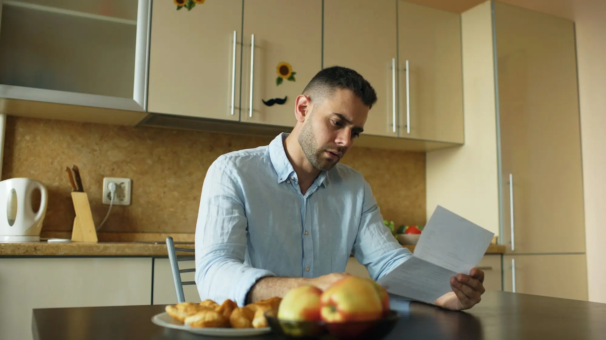 Business owner reading a tax letter at a kitchen table in Brisbane